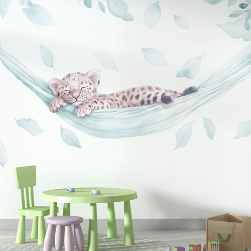Baby leopard wallpaper with a cub sleeping in a hammock of green leaves