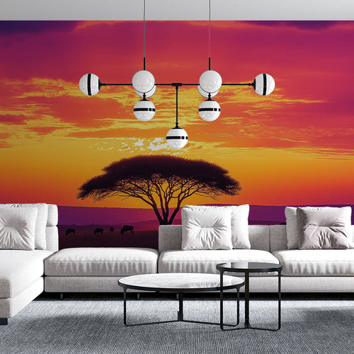 African landscape wallpaper of vibrant sunset with animal silhouettes under tree
