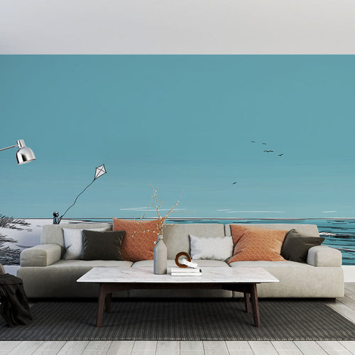 Beach wallpaper with a child flying a kite beside a turquoise sea